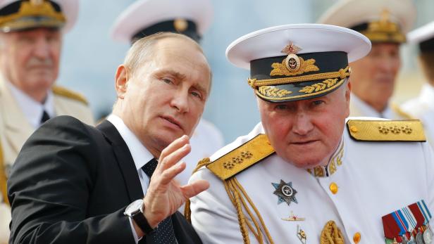 Russian President Vladimir Putin (L) chats with Commander-in-Chief of the Russian Navy Admiral Vladimir Korolev as they attend the military parade for Russia&#039;s Navy Day in Saint Petersburg on July 30, 2017. President Vladimir Putin oversaw a pomp-filled display of Russia&#039;s naval might as the Kremlin paraded its sea power from the Baltic Sea to the shores of Syria. Some 50 warships and submarines were on show along the Neva River and in the Gulf of Finland off the country&#039;s second city of Saint Petersburg after Putin ordered the navy to hold its first ever parade on such a grand scale. / AFP PHOTO / POOL / Alexander Zemlianichenko