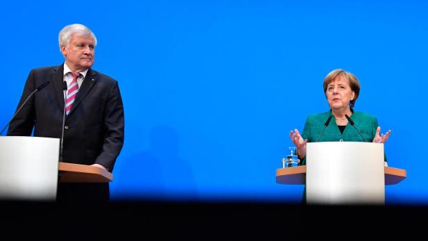 TOPSHOT - (L-R) Horst Seehofer, leader of the conservative Christian Social Union (CSU), German Chancellor Angela Merkel, leader of the conservative Christian Democratic Union (CDU), and Martin Schulz, leader of the social democratic SPD party, give a press conference in Berlin on February 7, 2018, after conservatives and the Social Democrats sealed a deal on a new coalition, potentially ending four months of political standstill in Europe&#039;s top economy. / AFP PHOTO / Tobias SCHWARZ