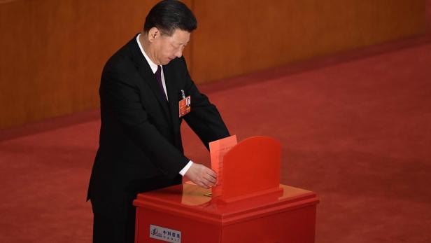 China&#039;s President Xi Jinping votes during the fifth plenary session of the first session of the 13th National People&#039;s Congress (NPC) at the Great Hall of the People in Beijing on March 17, 2018. China&#039;s rubber-stamp parliament unanimously handed President Xi Jinping a second term on March 17 and elevated his right-hand man to the vice presidency, giving him a strong ally to consolidate power and handle US trade threats. / AFP PHOTO / NICOLAS ASFOURI