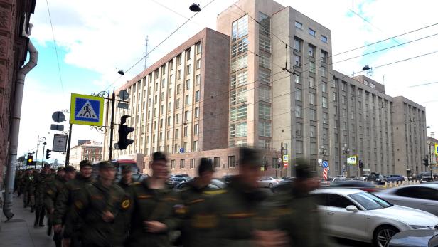 (FILES) In this file photo taken on June 10, 2016 Russian soldiers walk past the local headquarters of the FSB, the former KGB, where Vladimir Putin was recruited in 1975, in Saint Petersburg. Vladimir Putin was born and lived in Saint Petersburg previously named Leningrad for some 40 years, excluding his time as a KGB officer in East Germany, before moving to Moscow in the mid-1990s. / AFP PHOTO / Olga MALTSEVA