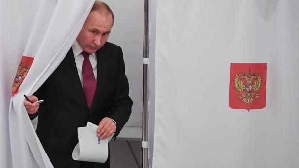 Presidential candidate, President Vladimir Putin walks out of a voting booth at a polling station during Russia&#039;s presidential election in Moscow on March 18, 2018. / AFP PHOTO / POOL / Yuri KADOBNOV