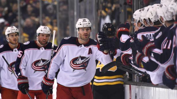 Eishockeyspieler der Columbus Blue Jackets gratulieren sich auf der Bank.