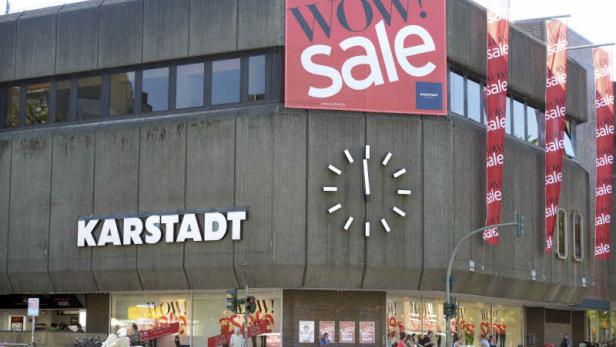 Das Karstadt-Gebäude mit einem großen „WOW! Sale“-Banner und einer Uhr an der Fassade.