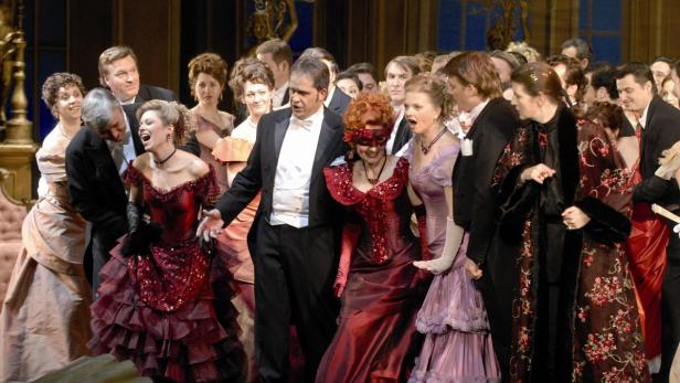 Eine Gruppe von Menschen in festlicher Kleidung auf einer Bühne.