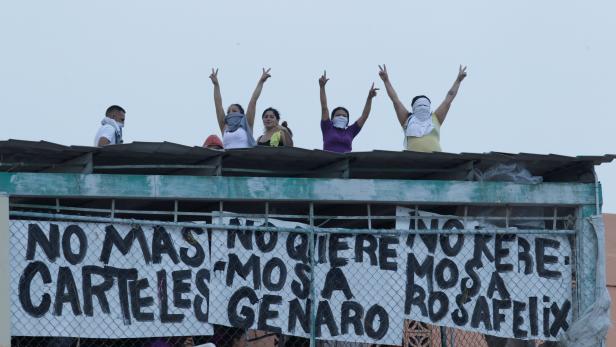 Inmates gesture while standing on the roof of the Topo Chico prison as they protest against the prison authorities in Monterrey