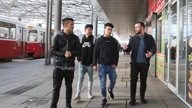 MMA-Kämpfer Tamirlan Dadaev (re.) am Praterstern im Gespräch mit drei jungen Afghanen