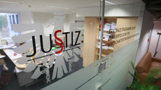 Die Aufschrift „Justiz“ und das zugehörige Logo auf einer Glastür.