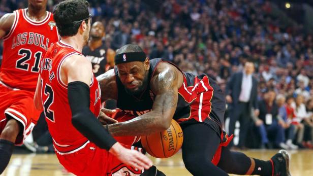 Chicago Bulls guard Kirk Hinrich (12) fouls Miami Heat forward LeBron James (R) during the first half of their NBA basketball game in Chicago, Illinois March 27, 2013. REUTERS/Jeff Haynes (UNITED STATES - Tags: SPORT BASKETBALL TPX IMAGES OF THE DAY)