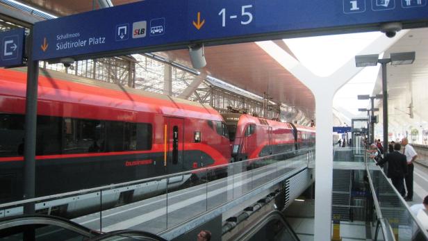Ein roter Railjet-Zug steht am Bahnsteig im Bahnhof Südtiroler Platz.