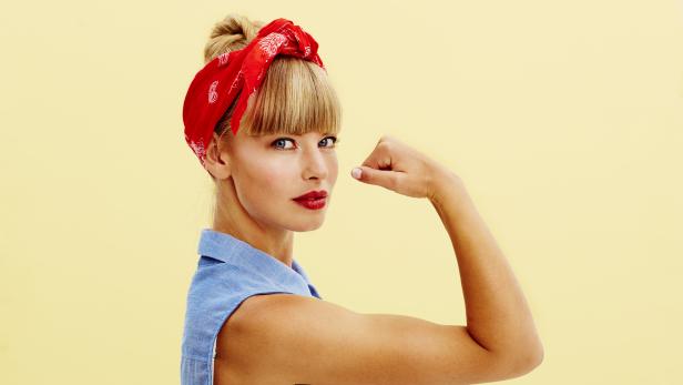 Strong blond woman flexing muscle