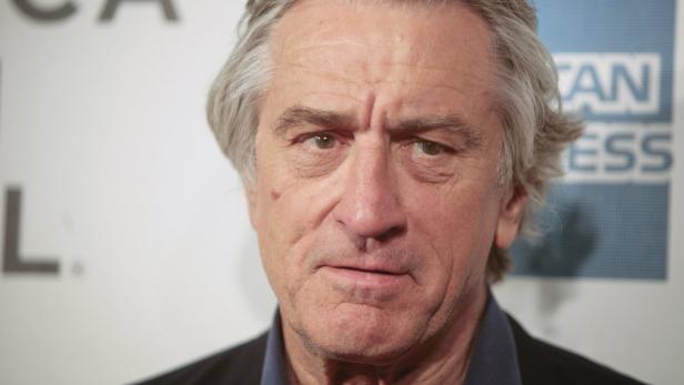 Porträt von Robert De Niro vor einer Wand mit dem American Express Logo.