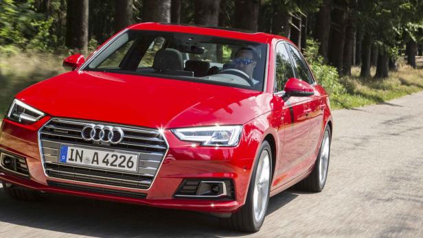 Ein roter Audi A4 fährt auf einer Landstraße.