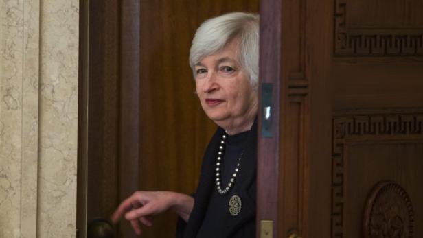Janet Yellen öffnet eine Tür.