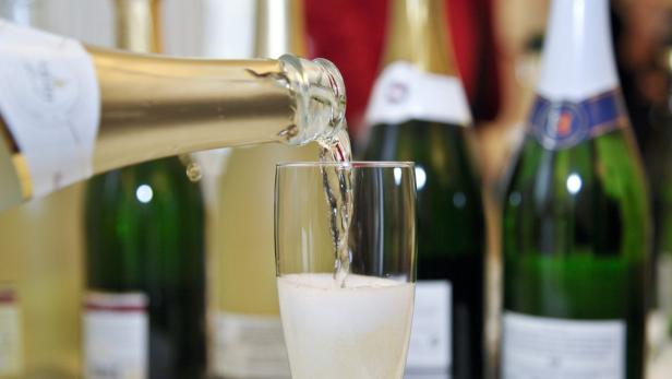 Champagner wird in ein Glas gegossen.