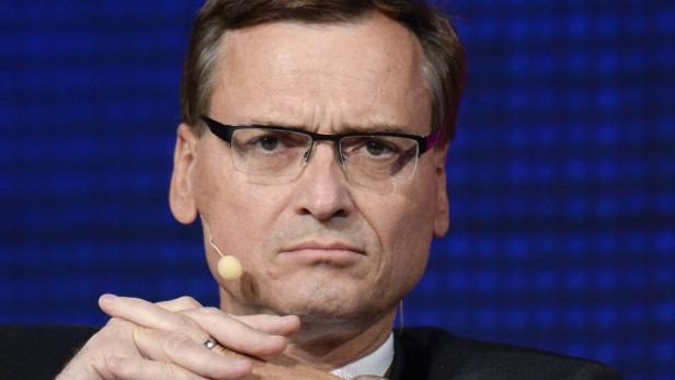 Ein Mann mit Brille und Mikroport blickt ernst in die Kamera.