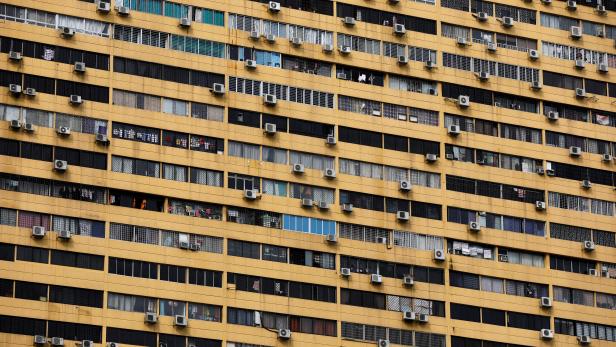 Air conditioning units dot the facade of a residential apartment block in Singapore