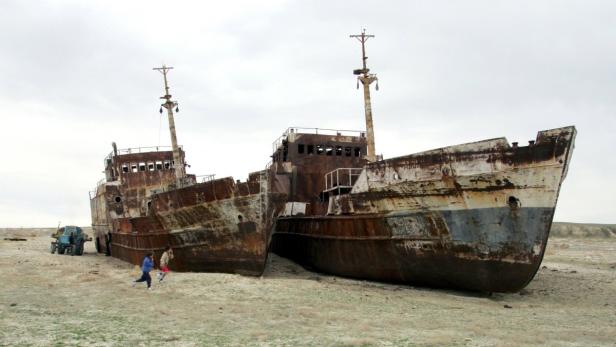 File photo of children running past ruined ships a