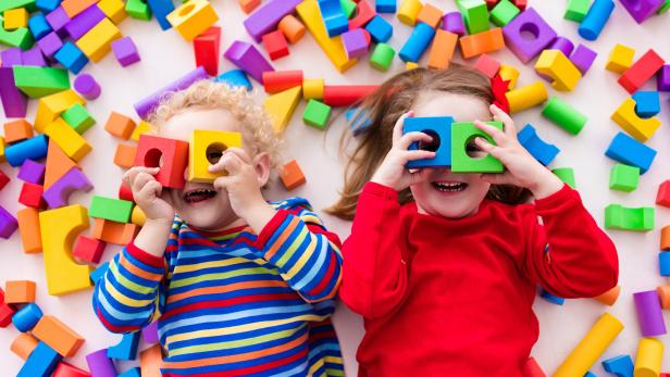 Funny children playing with colorful blocks.