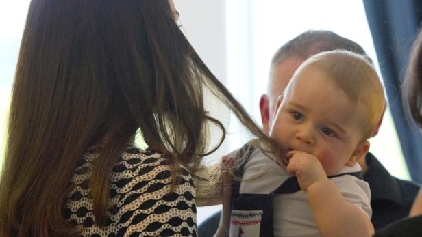Prinz George lutscht an einem Haarsträhne einer Frau.