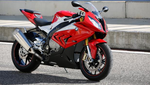 Ein rot-weißes BMW-Motorrad steht auf einer asphaltierten Fläche.