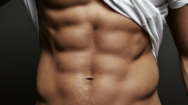 Closeup photo of an athletic guy with perfect abs