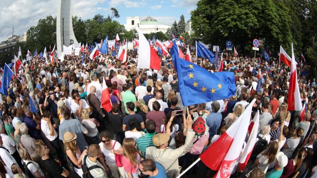 Protesters gather in front of the Parliament building during an opposition protest in Warsaw