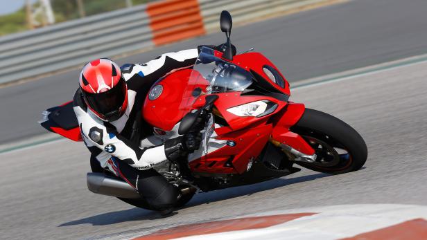 Ein Motorradfahrer fährt mit einer roten BMW auf einer Rennstrecke.