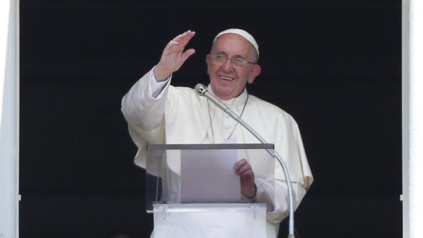 Papst Franziskus winkt von einem Balkon.