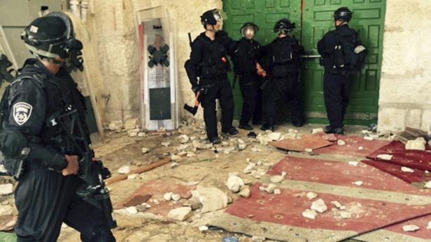 Israelische Polizisten vor dem Tor der Al-Asa-Moschee - in dem Gebetshaus hatten sich alästinenser mit Brandsätzen und Feuerwerkskörern verschanzt.
