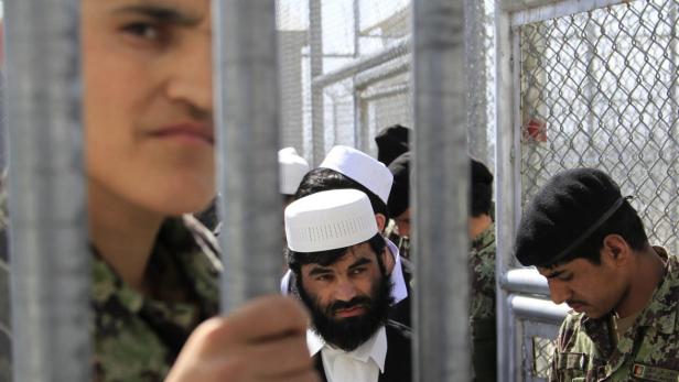 epa03640154 Afghan Army soldiers escort some 26 Afghan prisoners following their release during the Bagram Prison handover ceremony, on the outskirts of Kabul, Afghanistan, 25 March 2013. US forces in Afghanistan officially transferred control of Bagram jail to the Afghan Defence Ministry on 25 March, the international military forces said. The United States have repeatedly postponed the handover amid fears Taliban militants could be allowed to return to the battlefield. The Afghan government has renamed the facility the Afghan National Detention Facility at Parwan. EPA/S. SABAWOON