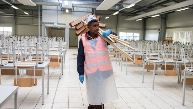 Symbolbild. Ein Flüchtling der in einem deutschen Aufnahmezentrum arbeitet.