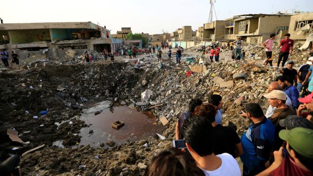 People gather at the site of an explosion in Baghdad