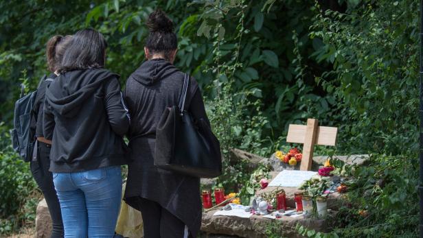 Junge Frauen legen an einer provisorischen Gedenkstätte für die getötete Susanna F. Blumen nieder