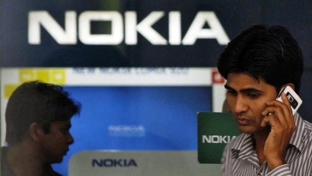 A customer speaks on his mobile phone as he comes out of a Nokia showroom in New Delhi March 28, 2013. Nokia has been served with an income tax demand of about 20.8 billion rupees for five fiscal years starting from 2006/07, according to a March 22 notice on the Delhi High Court website, in one of several tax disputes involving a foreign company. REUTERS/Mansi Thapliyal (INDIA - Tags: BUSINESS TELECOMS)