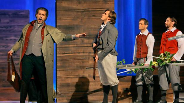 Szene aus einer Theateraufführung mit Männern in historischen Kostümen.