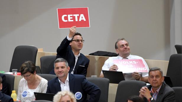 Der Abgeordnete Christian Kovacevic (SPÖ) mit einem Schild zu CETA im Rahmen einer Sitzung des Nationalrates 2018. (Symbolbild)