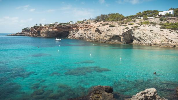 Eine malerische Bucht mit türkisfarbenem Wasser und einer felsigen Küste.