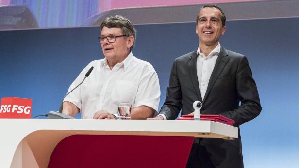 Zwei Männer stehen an einem Rednerpult bei einer Veranstaltung.