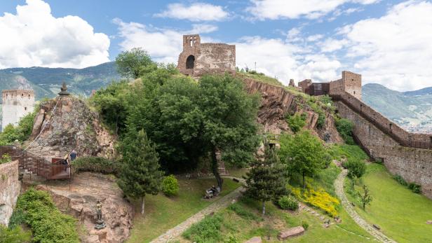 Blick auf Schloss Runkelstein in Bozen mit seinen Mauern und Türmen auf einem Hügel.