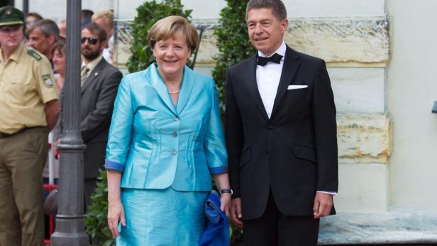 Angela Merkel und Joachim Sauer posieren für ein Foto.