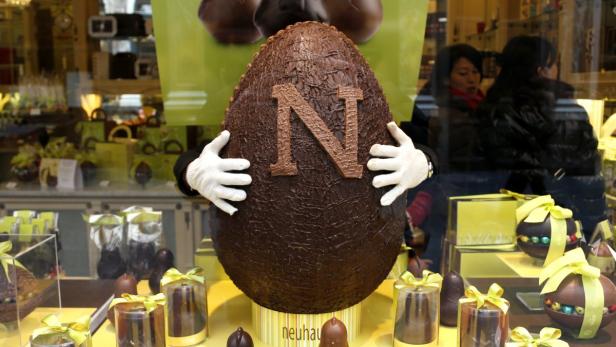 A vendor adjusts a giant chocolate egg at Belgian