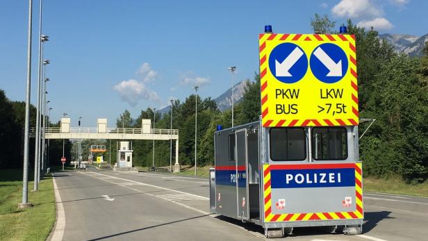 Ein mobiler Kontrollpunkt der Polizei steht an einer Straßengrenze.