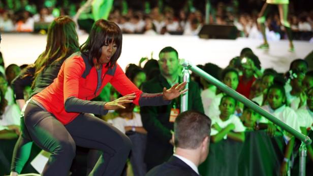 U.S. first lady Michelle Obama dances on stage with school children during an event to bring physical activity back to schools, hosted by the American Alliance for Health, Physical Education, Recreation and Dance (AAHPERD) and the Alliance for a Healthier Generation in Chicago, Illinois, February 28, 2013. REUTERS/Jeff Haynes (UNITED STATES - Tags: POLITICS EDUCATION HEALTH)