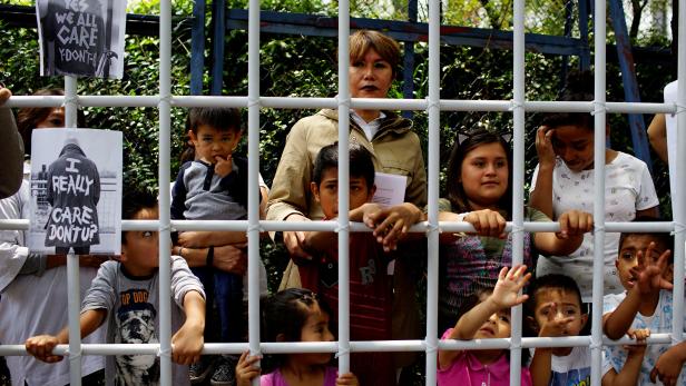 Lorena Osornio, an independent candidate for the Government of Mexico City, performs inside a simulated cage with children during a protest against U.S. immigration policies outside the U.S. embassy in Mexico City
