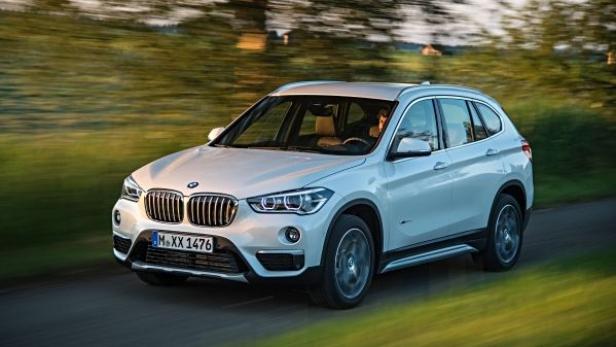 Ein weißer BMW X1 fährt auf einer Landstraße.