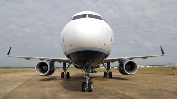 Ein weißes Passagierflugzeug steht auf einer Startbahn.