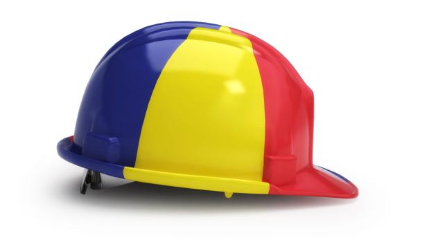 Ein Bauhelm in den Farben der rumänischen Flagge, blau, gelb und rot.