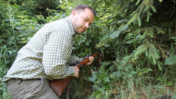 Jäger Sebastian Schmidt zeigt, wie schwierig es ist, mit einem Gewehr in eine Brombeerhecke einzudringen.