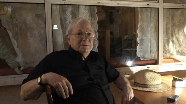 Israeli author Yoram Kaniuk poses for a photo at a cafe in Tel Aviv October 6, 2011. Yoram Kaniuk, a rambunctious 81-year-old author, was hailed by Israeli secularists this week for winning a court victory that compelled the state to stop listing Judaism as his &quot;religion&quot; while keeping &quot;Jewish&quot; as his &quot;ethnicity&quot;. He is the first Israeli Jew to have done so. REUTERS/Ronen Zvulun (ISRAEL - Tags: POLITICS SOCIETY)