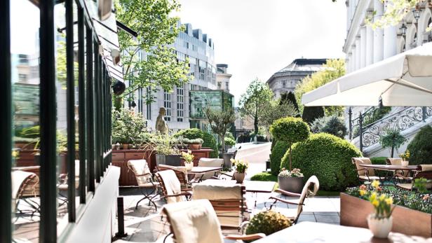 Einladende Terrasse eines Cafés mit Tischen und Stühlen im Freien.